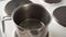 The cook pours water into a pot on an electric stove, close-up, cooking