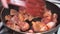 Cook prepares fried pieces of pork in a pan in the kitchen, close-up. Frying tasty meat.