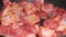 Cook prepares fried pieces of pork in a pan in the kitchen, close-up. Frying tasty meat.