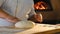 The cook prepares the pizza dough. A professional chef forms a round ball of yeast dough to prepare an appetizing pizza.