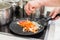 Cook prepares vegetable frying for soup in a frying pan