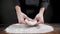 Cook prepares wheat dough for pizza on the black background