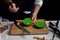 Cook preparing burger adding the sauce on green bun.