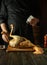 The cook is preparing a rooster on the kitchen table in a public house. Concept of cooking delicious chicken with salt and spices