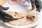 The cook puts fresh tortillas on a plate