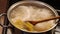 Cook removes the lid from the pot with the pasta in the hot water