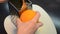 Cook rubs orange zest by hand on a grater