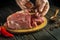 Cook\'s hand add aromatic spices to raw meat before grilling. Preparing beef meat before roasting