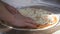 Cook`s hands in the kitchen putting the ingredients on the pizza. Pizza concept. Production and delivery of food