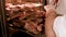 Cook`s hands preparing meat steaks on baking tray in oven