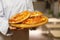 The cook shows a pitas on a wooden board