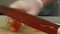 The cook slices red peppers with a knife on a cutting board in the kitchen.