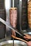 Cook Slicing Turkish Lamb Doner Kebab with a Sharp Sword like Knife