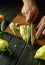 The cook slicing yellow fresh peppers on a cutting board to prepare a delicious vegetable dish. The concept of cooking vegetable