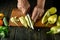 The cook slicing yellow fresh peppers on a cutting board to prepare a delicious vegetable dish. The concept of cooking vegetable