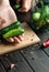 The cook sorts cucumbers before canning in a jar. Work environment on kitchen table with vegetables and spices. Peasant food