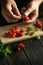 The cook sorts fresh strawberries before preparing cold drink in the kitchen. Close-up of chef hands while working. Free space for