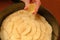 A cook squeezing out fresh lemon juice on top of a apple pie