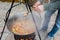 Cook stirring soup in a cauldron