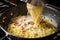 cook, stirring together eggs and cheese for the classic spaghetti carbonara