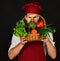 Cook with strict face holds veggies in basket.