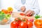 Cook in a white suit chopped vegetables in a glass bowl