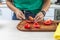 Cook woman cutting tomato salad knife kitchen