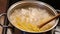 Cook with wooden spoon mixes the pasta in boiling water