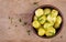 Cooked boiled potatoes with dill in bowl on wooden board.