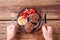 Cooked burger meat on wooden background with mens hands with fork and knife