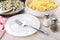 Cooked chicken liver in frying pan, pasta, empty plate, fork