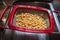 Cooked chickpeas in a drainer basket over a stainless steel sink - close-up and shallow focus