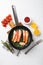 Cooked crab legs, in cast iron frying pan, on white stone table background, top view flat lay