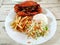Cooked crabs on white plate served with salad and french fries,