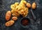 Cooked creamy peppercorn potato chips, snack crisps with sea salt on stone board with marble pestle and mortar.