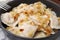 Cooked dumplings varenyky with tasty filling and fried onions in frying pan, closeup