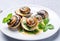 Cooked Escargots De Bourgogne snails with garlic butter and parsley on a plate in a restaurant, delicious and healthy food,