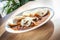 Cooked food in a restaurant on a white plate - beef stew with bread dumplings.