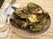 Cooked fried halves artichokes on brown plate