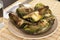 Cooked fried halves artichokes on brown plate