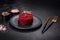 Cooked grated beetroot formed as a cylinder and ready dish on a black plate