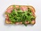 Cooked ham on a rectangular piece of bread spread with avocado purée