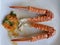 Cooked horse claws have a hard orange peel with spikes, a popular seafood dish, placed in a white plate.