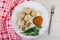 Cooked khinkali, squash caviar, dill in plate, fork, napkin on wooden table. Top view