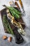 Cooked mackerel icefish on a wooden cutting board. Black background. Top view