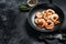 Cooked peeled king prawns, shrimps on a plate. Black background. Top view. Copy space