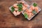 Cooked pink shrimps in the dish served with parsley. Shell-on North Atlantic prawns on the white plates on rustic wooden table.