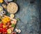 Cooked quinoa in cooking pot with fresh ingredients for salad making on dark rustic background, top view