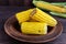 Cooked and raw corncobs on a dark wooden background