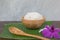 Cooked rice in bowl on green banana leaf and paddy in spoon and orchid .